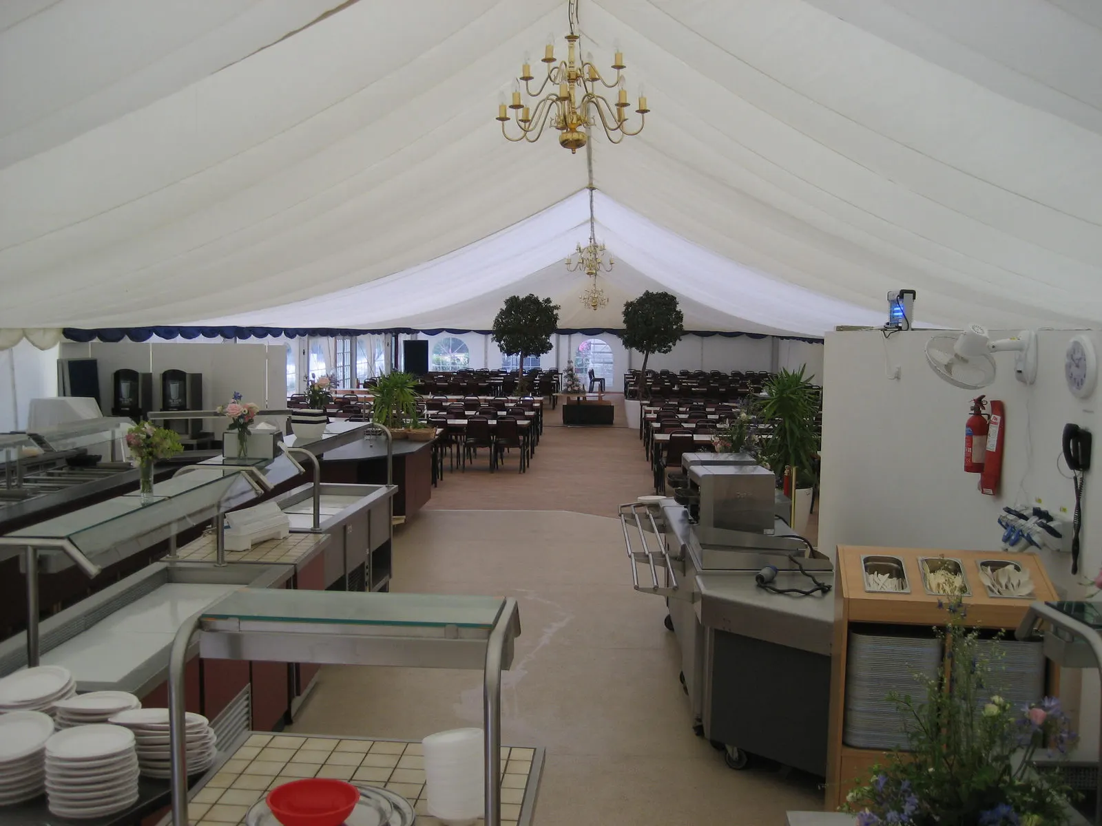 A catering area set up inside a marquee with serving counters