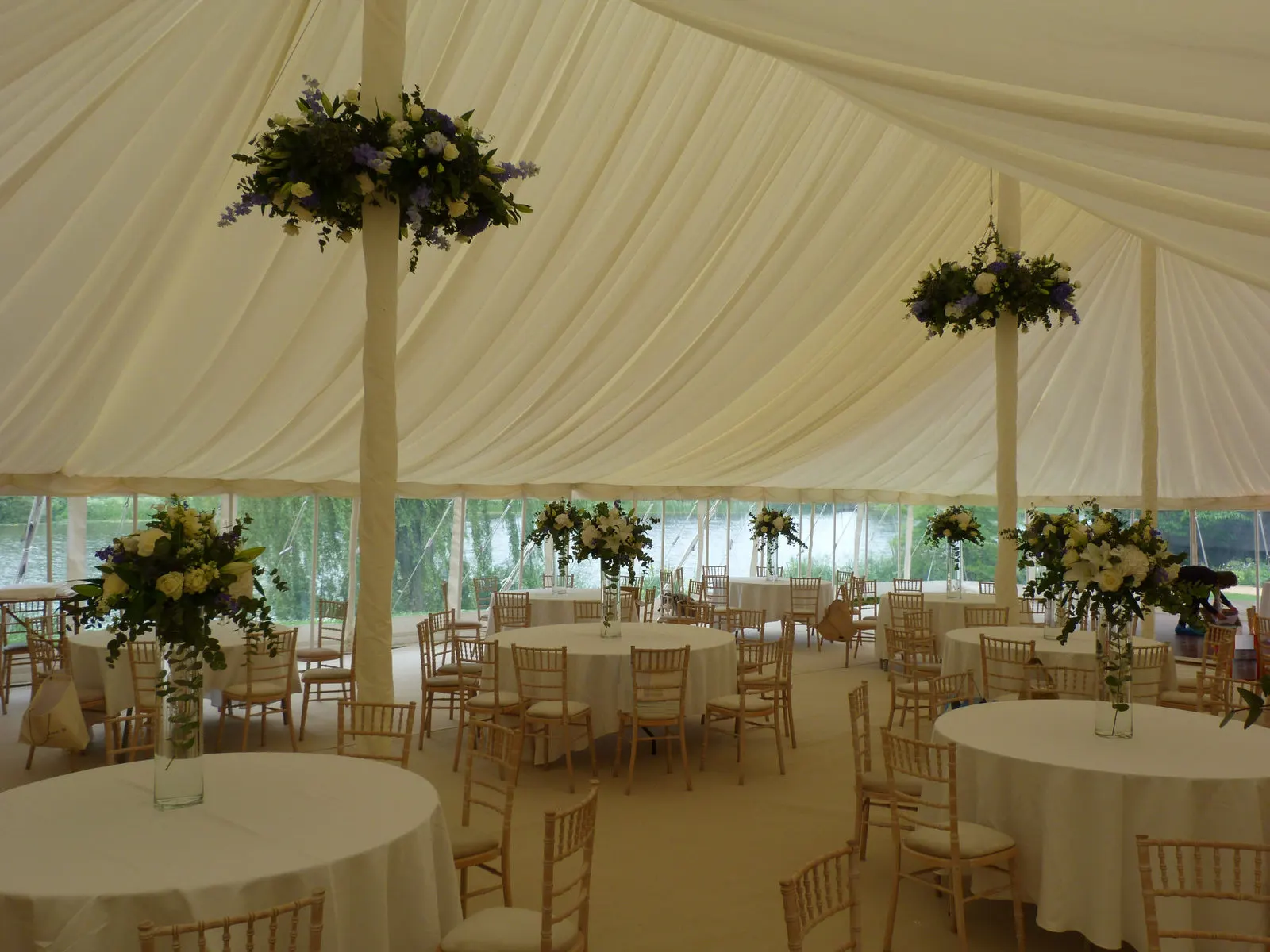 Floral arrangements hung from marquee poles