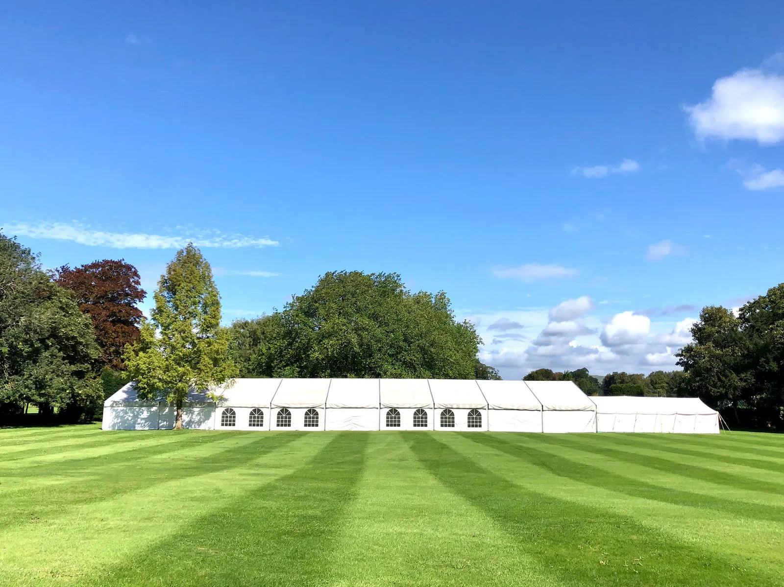 A long marquee on a striped lawn