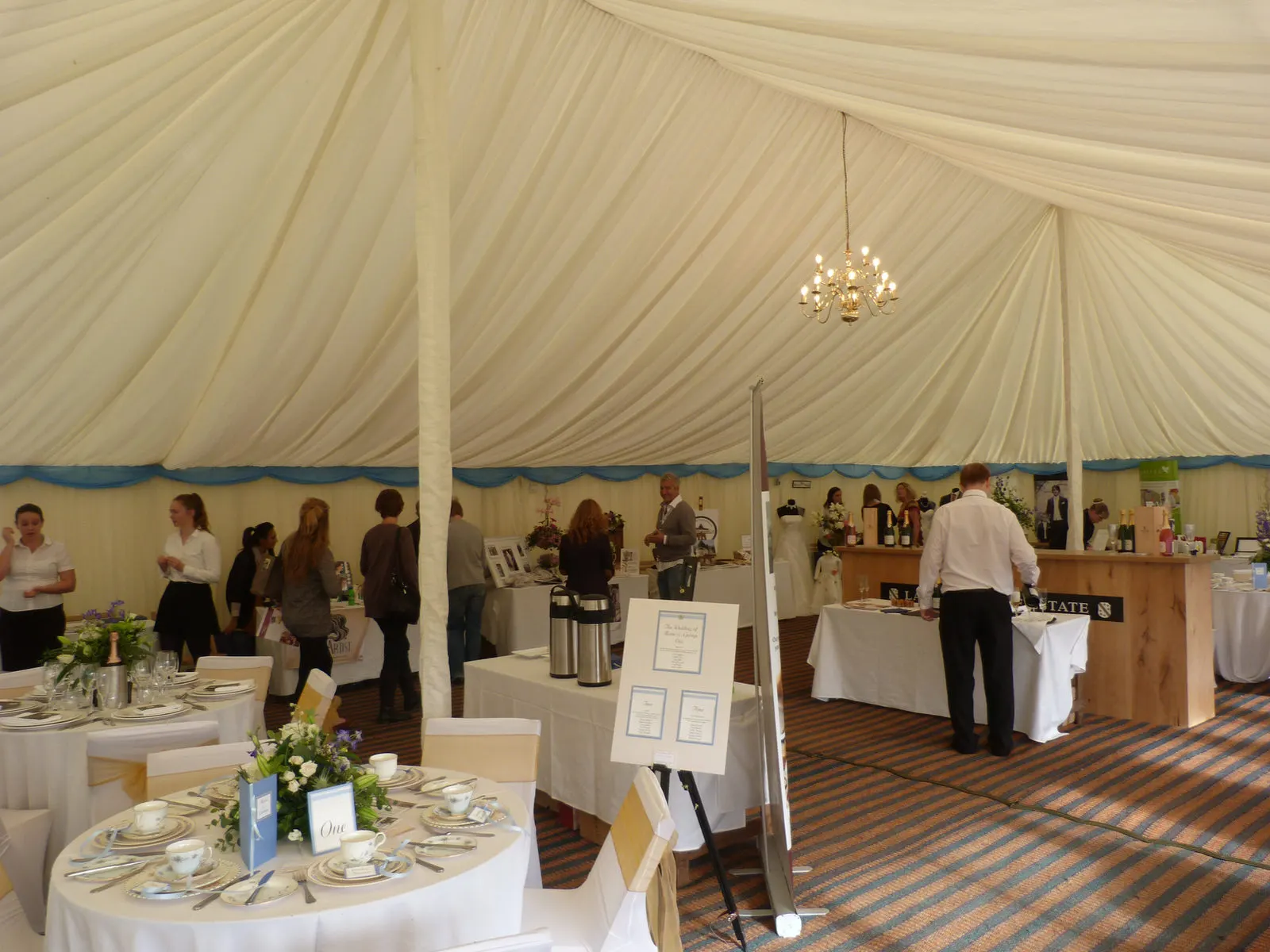 Guests at a buffet inside a lined marquee